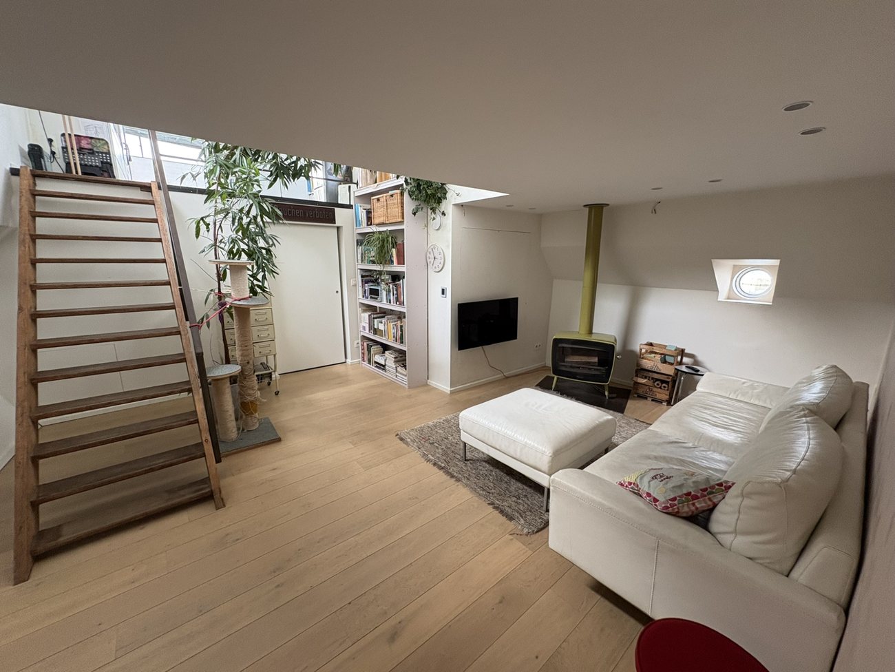 Woonkamer met zithoek, haard en trap